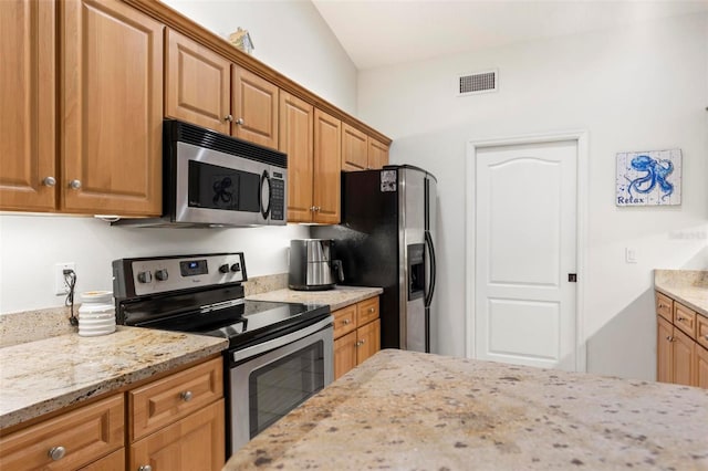 kitchen featuring light stone counters and appliances with stainless steel finishes