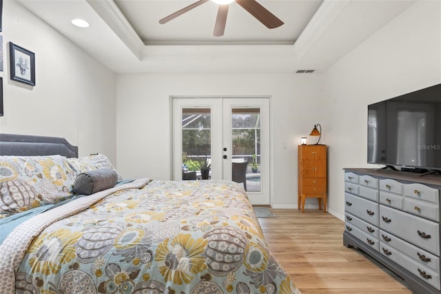 bedroom with access to outside, ceiling fan, a raised ceiling, light wood-type flooring, and french doors