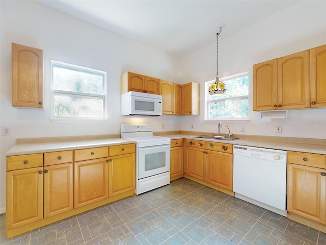 kitchen featuring pendant lighting, white appliances, and sink