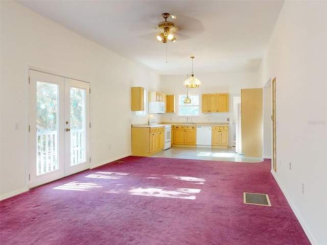 unfurnished living room with light carpet, french doors, ceiling fan, and sink