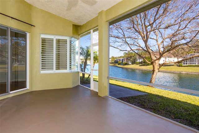 unfurnished sunroom featuring a water view