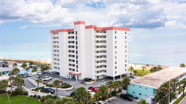 view of building exterior with a water view and a beach view