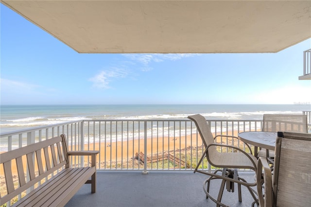 balcony with a water view and a beach view