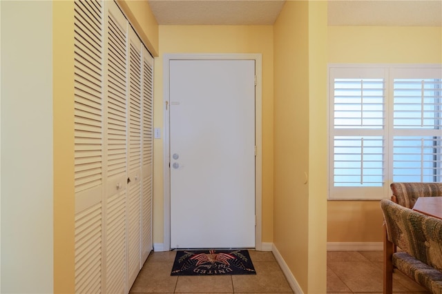 entryway featuring light tile patterned floors and a textured ceiling