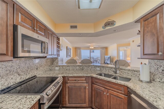 1183 Ocean Shore Blvd Unit 6040, Ormond Beach, FL 32176 - kitchen featuring appliances with stainless steel finishes, a sink, tasteful backsplash, a peninsula, and crown molding