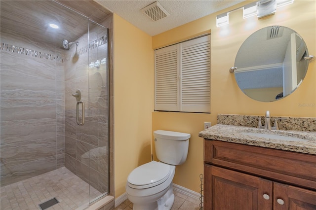 bathroom featuring tile patterned floors, vanity, a textured ceiling, a shower with door, and toilet