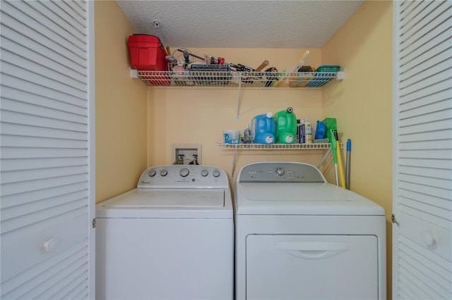 clothes washing area featuring a textured ceiling and separate washer and dryer