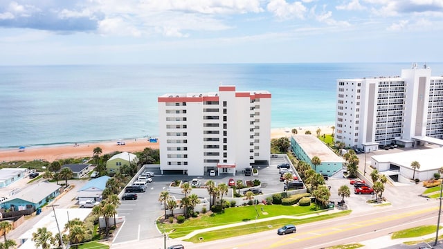 birds eye view of property with a water view and a beach view