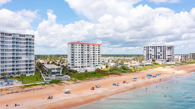 drone / aerial view featuring a water view and a view of the beach