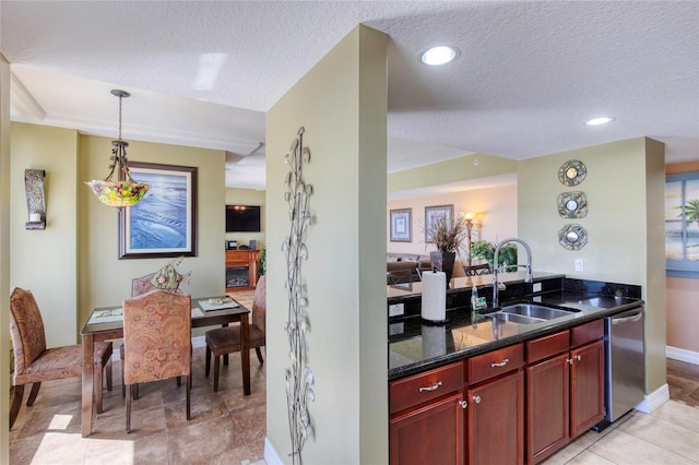 kitchen with dishwasher, sink, hanging light fixtures, dark stone countertops, and a textured ceiling