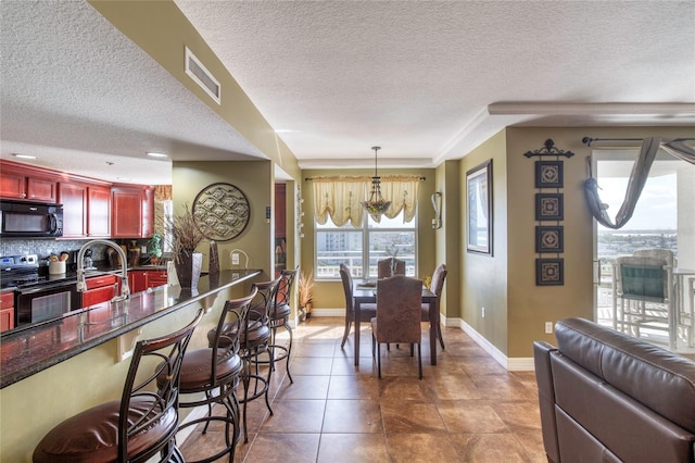 dining space with a textured ceiling, tile patterned floors, and sink