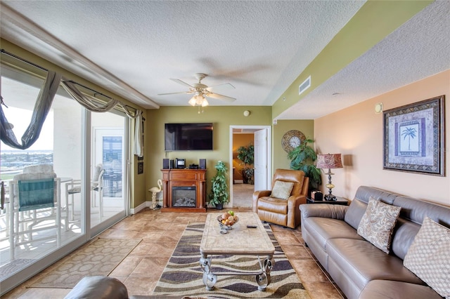 living room with a textured ceiling and ceiling fan