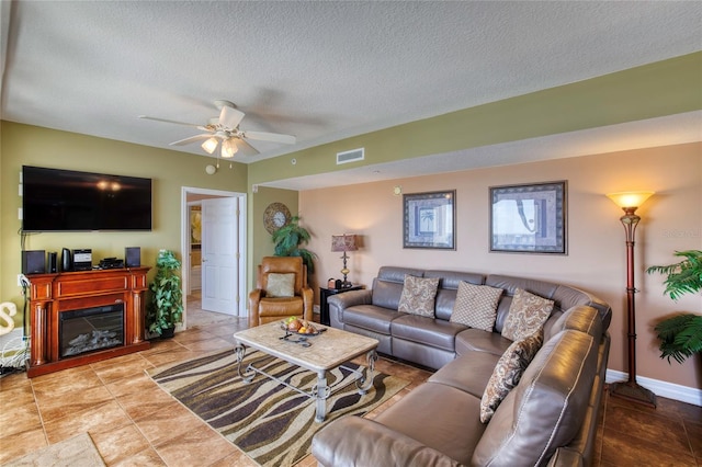 living room with ceiling fan and a textured ceiling