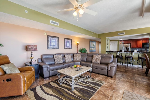 living room featuring a textured ceiling and ceiling fan