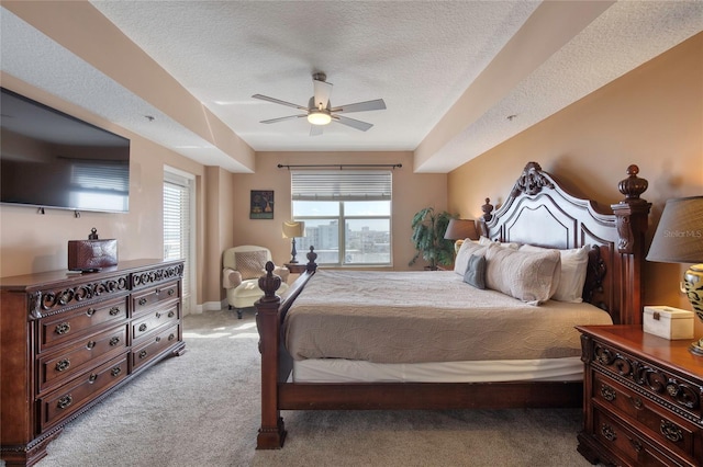 bedroom featuring ceiling fan, light colored carpet, and a textured ceiling