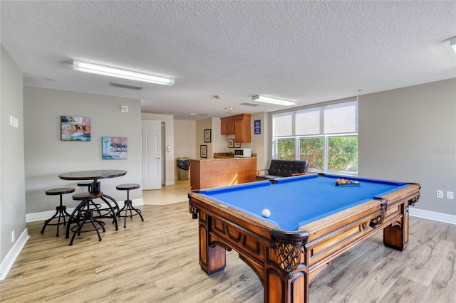 playroom with a textured ceiling, light hardwood / wood-style floors, and pool table