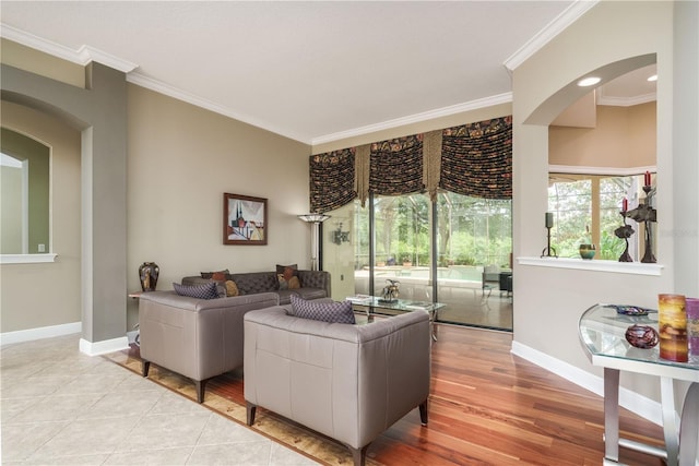 living room featuring baseboards, ornamental molding, and light wood-style flooring