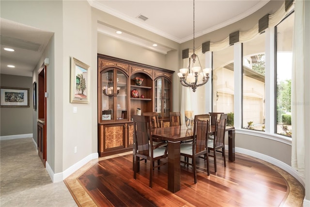 dining room with a chandelier, wood finished floors, visible vents, baseboards, and ornamental molding