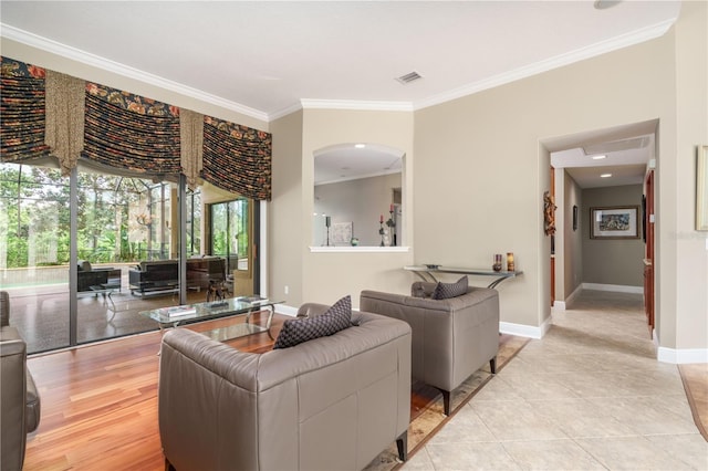 living area featuring ornamental molding, light tile patterned flooring, visible vents, and baseboards