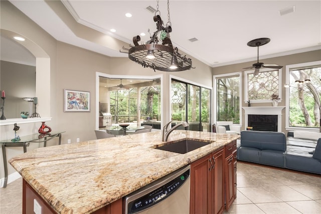 kitchen with a fireplace, stainless steel dishwasher, ornamental molding, open floor plan, and a sink