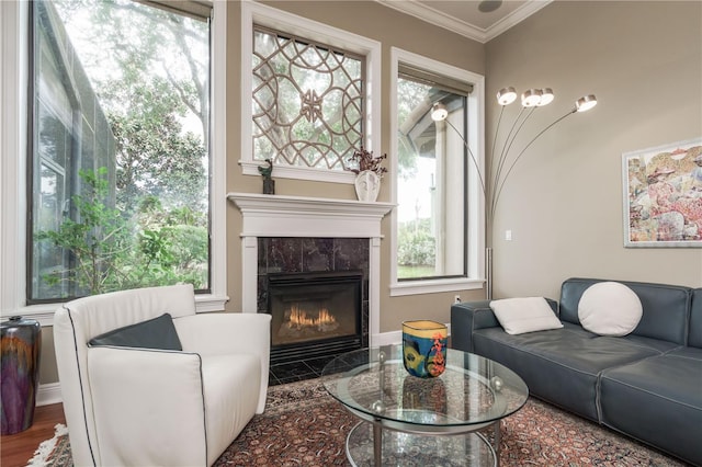 living area with a wealth of natural light, a tile fireplace, and ornamental molding