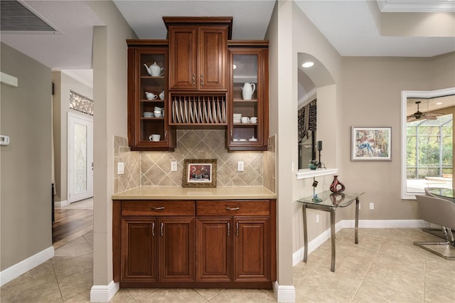 bar with tasteful backsplash, visible vents, baseboards, and light tile patterned flooring