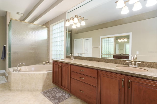 bathroom featuring a stall shower, tile patterned flooring, a garden tub, and a sink