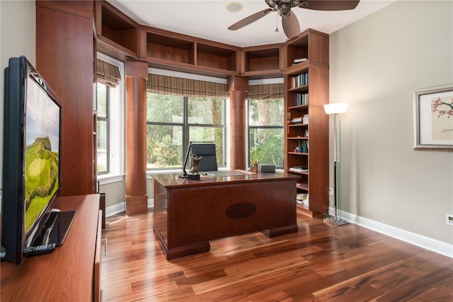 home office with ceiling fan, decorative columns, baseboards, and wood finished floors