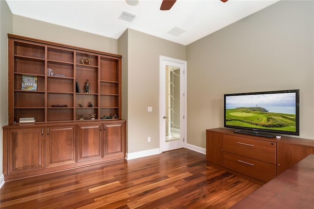 interior space featuring a ceiling fan, baseboards, visible vents, and dark wood-style flooring