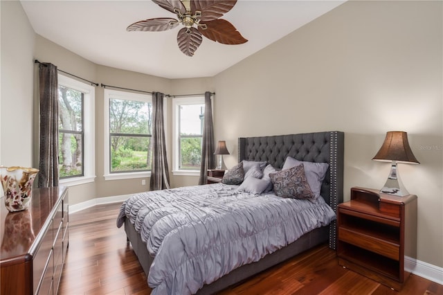 bedroom with ceiling fan, wood finished floors, and baseboards