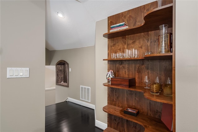 hall featuring lofted ceiling and visible vents