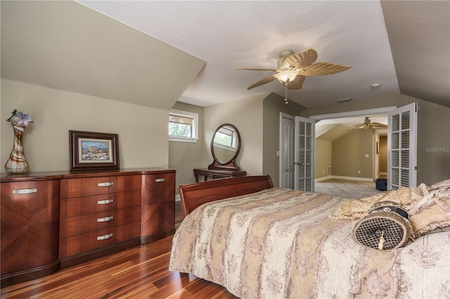 bedroom featuring lofted ceiling, a ceiling fan, a textured ceiling, wood finished floors, and baseboards