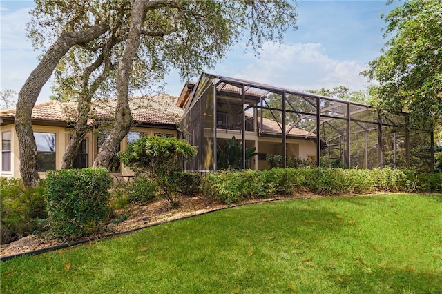 back of house featuring a lanai, a yard, and a tiled roof