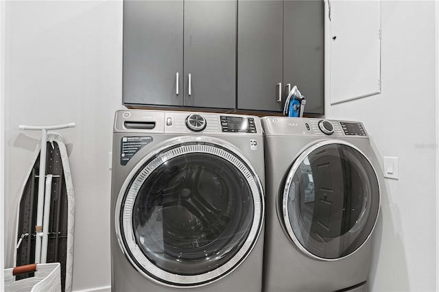 laundry room with washer and clothes dryer and cabinets