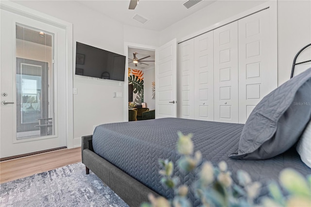 bedroom with hardwood / wood-style flooring, ceiling fan, and a closet