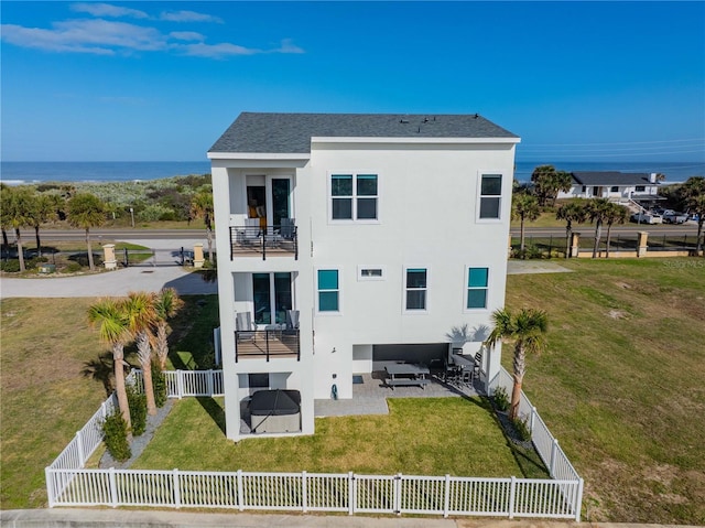 back of property featuring outdoor lounge area, a lawn, a water view, a balcony, and a patio