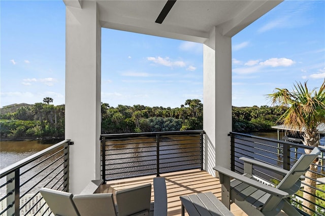 balcony with a water view and ceiling fan