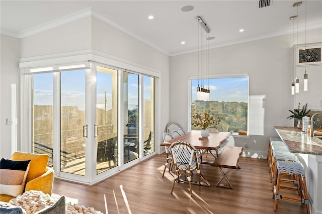 dining room with wood-type flooring and crown molding