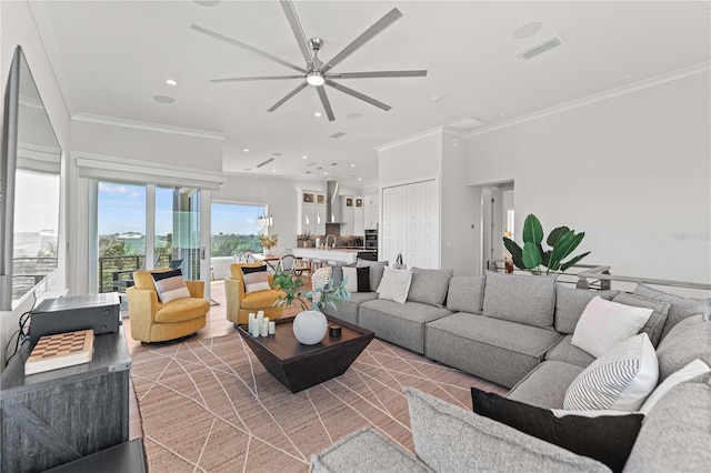 living room with crown molding, light hardwood / wood-style flooring, and ceiling fan