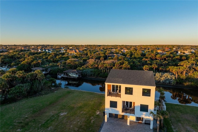 aerial view at dusk featuring a water view