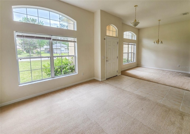 entrance foyer with light carpet and a high ceiling