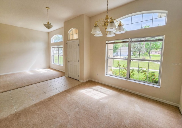 carpeted entryway with an inviting chandelier and a healthy amount of sunlight