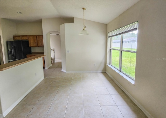 interior space with light tile patterned floors and lofted ceiling