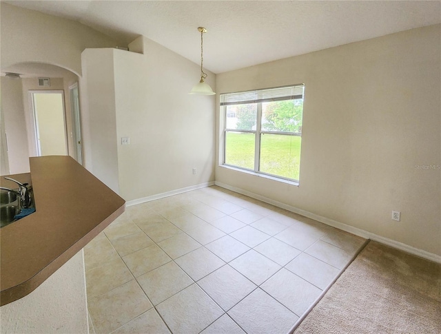 unfurnished dining area with light tile patterned floors and sink