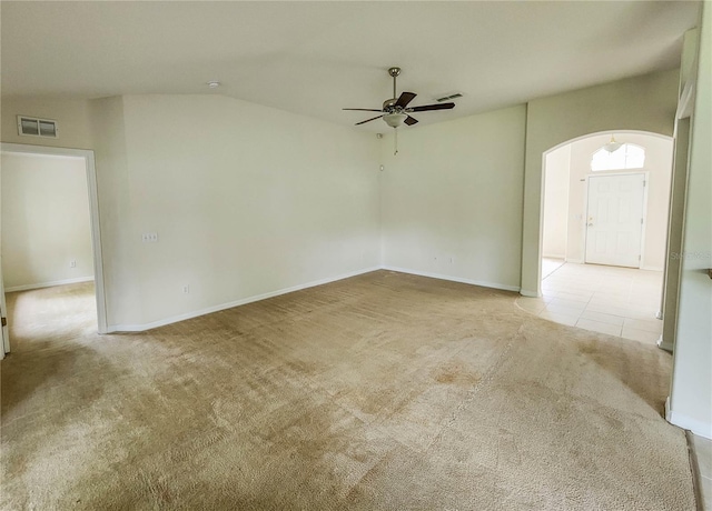 carpeted spare room with ceiling fan and vaulted ceiling