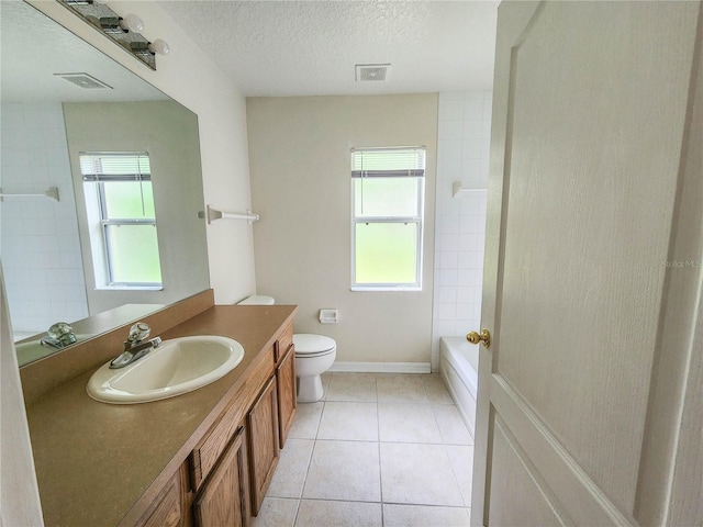 full bathroom featuring vanity, tiled shower / bath, tile patterned flooring, toilet, and a textured ceiling