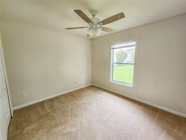 carpeted spare room featuring ceiling fan