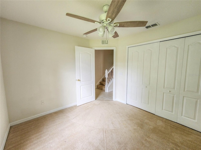 unfurnished bedroom with ceiling fan, a closet, and light colored carpet