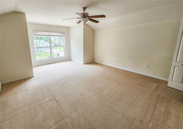 carpeted empty room featuring a textured ceiling, ceiling fan, and lofted ceiling