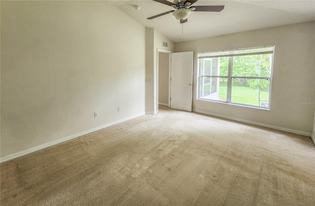 spare room featuring ceiling fan, light colored carpet, and vaulted ceiling